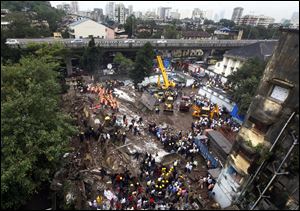 Indian Fire officials look for survivors from debris of a collapsed building in Mumbai, India. The multi-story residential building collapsed in India's financial capital of Mumbai early today, killing at least three people.