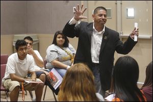 Roberto Torres, director of the Northwest Ohio Hispanic Chamber of Commerce, offers advice to high school students during a career day for Latinos on Friday at Bowling Green State University. 