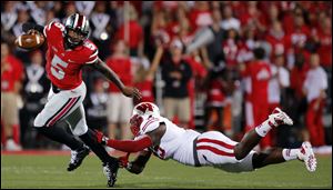 Ohio State QB Braxton Miller (5) eludes Wisconsin NG Warren Herring (45) during the first quarter.
