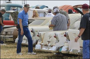 Car buffs look over Chevrolet vehicles during a preview for an auction of vintage cars and trucks from the former Lambrecht Chevrolet dealership in Pierce, Neb., Friday Sept. 27, 2013. The auction takes place on Saturday and Sunday. (AP Photo/Nati Harnik)