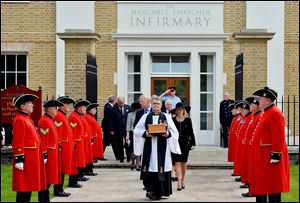 Reverend Richard Whittington carries an oak casket containing the ashes of former British Prime Minister Margaret Thatcher, followed by her daughter Carol, son Mark and his wife Sarah after leaving the chapel today at the Royal Hospital Chelsea in London.