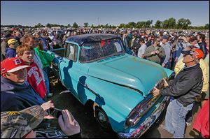 Crowds mill around a rare sky-blue, 1958 Chevy Cameo pickup driven 1.3 miles. It sold at the Lambrecht Chevrolet auction Saturday for $140,000.