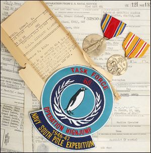 Service papers, medals and a mission patch belonging to Edward Becker at his Maumee home, Friday, Sept. 13, 2013.