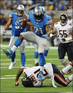 Lions running back Reggie Bush jumps over Chicago Bears strong safety Major Wright during an 37-yard touchdown run in the second quarter Sunday at Ford Field in Detroit. He ran for a season-high 139 yards on 18 carries.