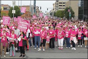 Pink-clad participants wait for the Komen Northwest Ohio Race for the Cure to start in downtown Toledo. Thousands ran or walked on Sunday, some carrying signs dedicated to the struggle of loved ones with cancer. The Toledo-area race draws more than 19,000 participants and raises more than $1,000,000 annually.