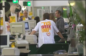A cashier of a do-it-yourself store wears a shirt to protest the court decision last week to force short working hours on Sundays, in Gennevilliers, France.