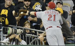 Cincinnati Reds third baseman Todd Frazier (21) reaches into the photographers' pit to catch a fly ball by Pittsburgh Pirates' Justin Morneau in the third inning.