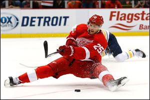 Detroit Red Wings center Cory Emmerton (25) tries to shoot after being brought down by Buffalo Sabres left wing Thomas Vanek (26) in the second period.  Emmerton was awarded a penalty shot on the tripping penalty.