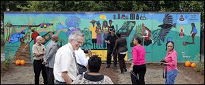 A mural dedicated to a slain toddler was unveiled at the Moody Manor apartment complex Tuesday afternoon. The 32-foot by 8-foot installation, by local artists Warren and Yolanda Woodberry, depicts farm scenes and, on the last of eight panels, Keondra Hooks resting on a cloud. Keondra, 1, died of a single gunshot wound to the head after being shot at the apartment complex on Aug. 9, 2012.