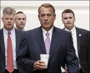 House Speaker John Boehner of Ohio walks to a Republican strategy session on Capitol Hill in Washington today.