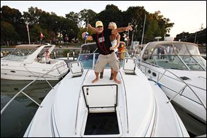 Donnie Jenei and Vicki Price of Stow, Ohio, dance on the bow of Mr. Jenei's boat as they celebrate a friend's bachelorette party. Mr. Jenei has been coming to Put-in-Bay for more than 30 years. 