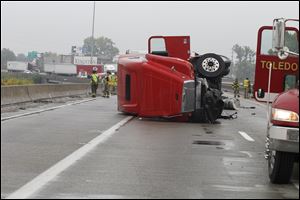 Firefighters stand by at an overturned truck on N I-75 south of Toledo.