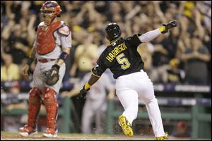 Pittsburgh Pirates pinch-runner Josh Harrison scores from second on a Pedro Alvarez single in the eighth innings as Cardinals catcher Yadier Molina awaits a possible throw.