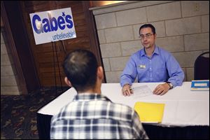 Mark Blazer, an assistant manager at Gabe's of Lexington, Ky., interviews Ron Morton of Curtice, Ohio, during a job fair Monday held by Gabriel Brothers Inc. at the Ramada Toledo Hotel. 