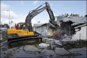 The former Arbors of Toledo on Cherry Street in Toledo is demolished on Monday.   The city of Toledo, Lucas County Land Bank, Mercy Health Partners, Cherry Street Legacy Project, and neighbors of the Bronson Place Association are involved in the project to transform the site into green space. 