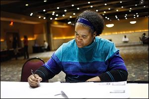 Toledo resident Holly Matthews fills out paperwork during a job fair held on Monday by Gabriel Brothers Inc. at the Ramada Toledo Hotel. Gabe's will be opening a new store in Sylvania Township.