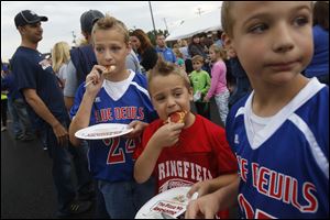 Brothers Joshua, 11, left, Garren, 7, center, and Welden Hannum, 10, enjoy pizza during a kick-off event last week to support a 2.9-mill levy on the November ballot for Springfield Local Schools. 
