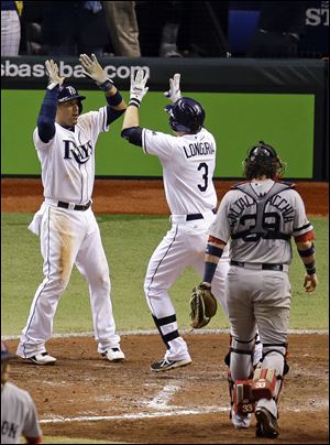 Tampa Bay Rays' Evan Longoria (3) celebrates his fifth inning three-run home run with teammate Yunel Escobar, left, as Boston Red Sox catcher Jarrod Saltalamacchia walks back to the batter's box.