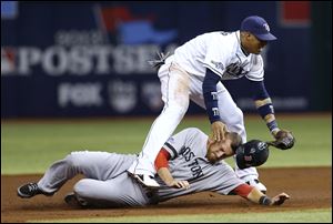 Boston Red Sox's Will Middlebrooks (16) slides under Tampa Bay Rays shortstop Yunel Escobar (11) after he was tagged out on a double play in the third inning.