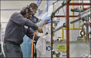 Employees at Sheffield Platers Inc. work on the factory floor in San Diego. Since the shutdown which started on Oct. 1, the company has focused on filling previously approved purchase orders, but if the government remains closed, President Dale L. Watkins Jr. says there could be layoffs among his 70 workers. 