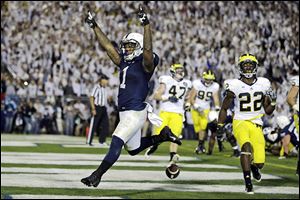 Penn State’s Bill Belton runs past Michigan’s Jarrod Wilson, right, for a two-yard touchdown during the fourth overtime.