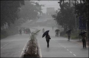 Indians hold umbrellas as they head to a cyclone shelter in  Chatrapur in Ganjam district, today, about 125 miles from the eastern Indian city Bhubaneswar, India.