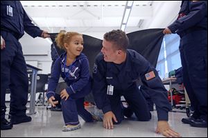 Makayla Tidwell, 4, races Nick Wolfe, 16, of Genoa in a Penta program for Fire Prevention Week.  Preschoolers were learning the importance of crawling to get out of a building filled with smoke. 