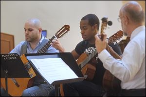 Michael Ziegler, left, and Denzell Anderson, center, played a classical guitar piece with their teacher, Ken Hummer, during Lourdes' Fall Music Showcase at the Franciscan Center on Sunday in Sylvania.
