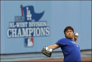 Dodgers starting pitcher Hyun-Jin Ryu practices in the outfield of Dodgers Stadium on Sunday in preparation for today’s Game 3 against the St. Louis Cardinals. He says his arm feels strong.