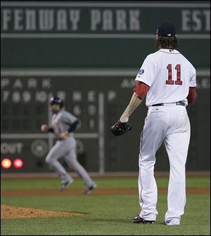 Red Sox starting pitcher Clay Buchholz watches as the Tigers' Alex Avila runs the bases after Avila hit a two-run home run in the sixth.