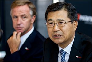 Seung Hwa Suh, vice chairman and CEO of Hankook Tire Co., speaks to reporters about the company's decision to build its first U.S. plant in Clarksville, Tenn., as Gov. Bill Haslam, left, looks on. 