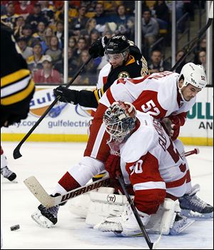 Red Wings goalie Jonas Gustavsson, right, and defenseman Jonathan Ericsson protect the net against Boston’s Reilly Smith on Monday afternoon.