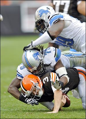 Browns quarterback Brandon Weeden is sacked by Lions defensive end Willie Young and C.J. Mosley in the third quarter. The second-year player has been criticized this season for holding the ball too long, making him one of the most-sacked quarterbacks in the league.
