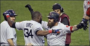 Boston’s David Ortiz, center left, celebrates with Mike Napoli after Napoli’s solo home run during the seventh inning provided the only run in Game 3 of the ALCS against the Tigers on Tuesday evening  in Detroit. The Red Sox lead the best-of-seven series 2-1.