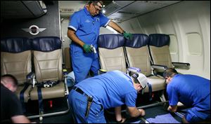 Southwest Airlines technicians install newer, skinnier seats on a 737 at the carrier’s headquarters in Dallas. The airline says the extra row of seats should not cut down legroom for passengers.