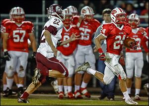 Eastwood's Brent Schlombohm, who had 104 yards rushing, runs past Rossford's Noah Asmus.