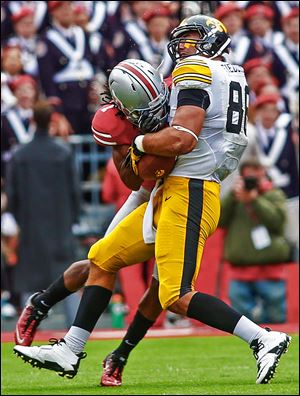 Ohio State cornerback Bradley Roby, left, tackles Iowa tight end C.J. Fiedorwicz with a hard hit in the first quarter. Roby was ejected from the game for a targeting penalty.