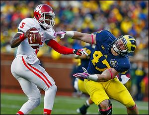 Michigan’s Jake Ryan just misses Indiana quarterback Tre Roberson, who threw for 288 yards and ran for 50.