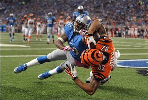 Cincinnati Bengals wide receiver Marvin Jones catches a 12-yard touchdown as Lions cornerback Chris Houston defends in the second quarter Sunday in Detroit.