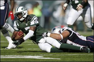 New York Jets quarterback Geno Smith is sacked by New England Patriots lineman Chris Jones on Sunday in East Rutherford, N.J. Jets kicker Nick Folk was wide left on a 56-yarder in overtime, but the miss was negated when Jones, a star at Bowling Green State University, was called for unsportsmanlike conduct for pushing a teammate forward to try to block the kick. It marked the first time that new penalty has been called in an NFL game.