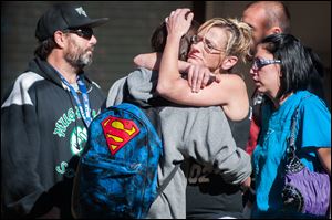 A Sparks Middle School student, back to camera, cries with family members after being released from Agnes Risley Elementary School today in Sparks Nev., after a shooting at Sparks Middle School.