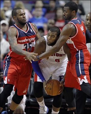 Detroit Pistons center Greg Monroe, center, is trapped in a corner by Washington Wizards forward Trevor Booker (35) and guard John Wall during the first half.