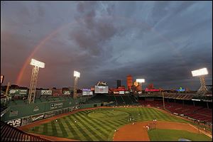Boston Red Sox players take batting practice as a rainbow appears in the sky above Fenway Park Tuesday, Oct. 22, 2013, in Boston. 