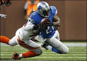 Detroit Lions running back Reggie Bush (21) is brought down by Cincinnati Bengals free safety Reggie Nelson (20) in the first quarter of an NFL football game Sunday, Oct. 20, 2013, in Detroit. (AP Photo/Rick Osentoski)
