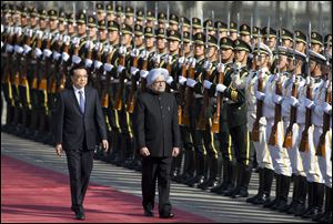Indian Prime Minister Manmohan Singh, right, is accompanied by Chinese Premier Li Keqiang, left, as they inspect an honor guard during a welcome ceremony outside the Great Hall of the People in Beijing, China, today.