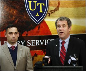 U.S. Senator Sherrod Brown, right, outlines a plan that would reduce unemployment among recently-returned service members and ease their transition into the civilian workforce, during a news conference at the University of Toledo Military Service Center. At left is Lt. Haraz Ghanbari, USNR, University of Toledo military liaison.