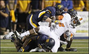 Bowling Green receiver Shaun Joplin is brought down by Toledo defenders Sylvestre, 33, Mark Singer, 43, and Cheatham Norrils, 11, during the football game at the Glass Bowl in 2012.