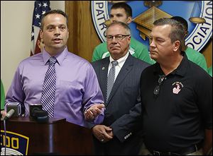 Dan Wagner, left, of the Toledo Police Patrolman's Association joins D. Michael Collins and Capt. Jeffrey Romstadt of Toledo Firefighters Local 92. The firefighters union has yanked its endorsement of Adam Martinez for comments about Mr. Collins. 