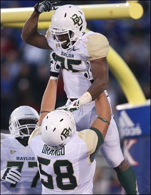 Baylor Bears running back Lache Seastrunk, top, is hoisted into the air by Spencer Drango (58) after scoring in the first quarter Saturday in Lawrence, Kan. 