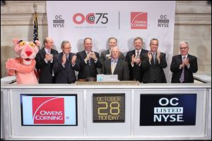 With help from company spokesman the Pink Panther, officials from Owens Corning including Chairman and CEO Michael H. Tha-man, third from left, ring the closing bell at the New York Stock Exchange on Monday to mark the company’s 75th anniversary. The Toledo-based company, which makes building materials and other fiber-glass products, was founded Oct. 31, 1938.